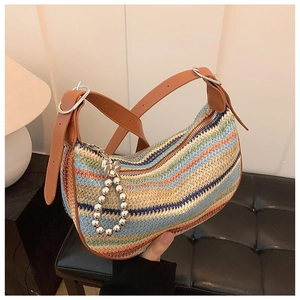 Macro detail of a colorful striped woven straw bag with adjustable leather strap
