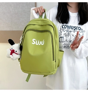 Detail of avocado green canvas backpack with white puppy pendant and Suju letter print