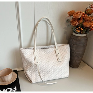 Close-up of the large white woven tote bag showing detailed Intrecciato leather texture
