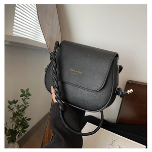 Close-up of black crossbody bag featuring cross-grain texture and woven rope handle