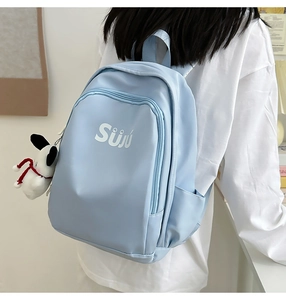 Detail of light blue waterproof nylon backpack with cute charm and letter print