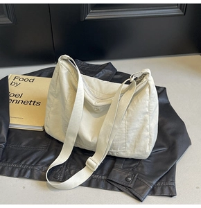 Detail of the cream-colored waterproof nylon tote bag featuring adjustable shoulder straps