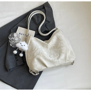 Gros plan détaillé du sac motif marbre avec breloque nuage en peluche et sangle