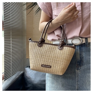 Detailed straw tote bag with brown leather handles and decorative knotted accents