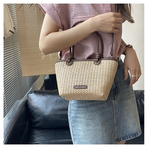 Detail of straw woven bag with leather handle and Micro beauty logo label