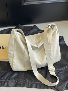 Off-white lightweight large capacity crossbody bag with wide strap for daily commute