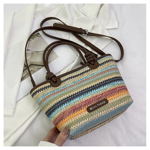 Macro view of colorful woven straw texture with premium brown leather strap and brand logo