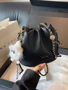 Sac seau élégant en cuir noir avec bandoulière chaîne dorée et pendentif en peluche