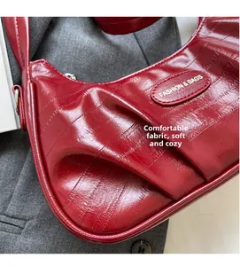 Détail du sac rouge en similicuir crocodile avec finition brillante et logo en métal