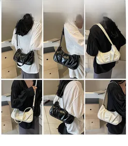 Vues détaillées des sacs croissants plissés en finitions cuir noir et crème épuré