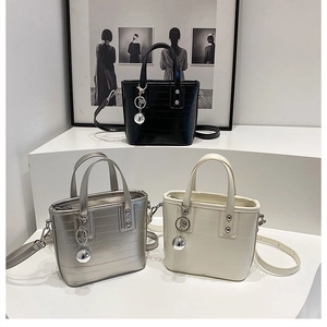 Trois élégants sacs seaux texturés en noir, argent et crème avec breloques à billes