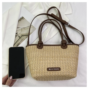 Detail of straw woven basket bag with leather handles and Micro beauty logo tag