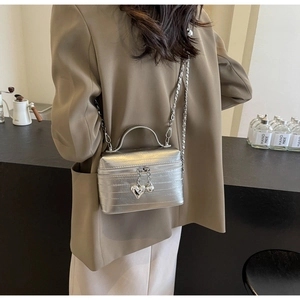 Sac boîte argenté métallisé avec texture, fermeture cœur et bandoulière chaîne élégante