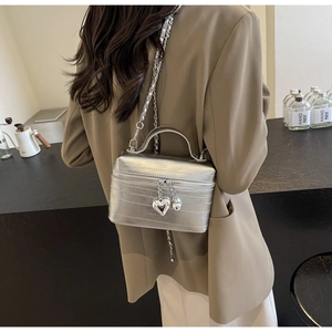 Sac bandoulière argenté métallisé à rayures texturées avec pendentif en cœur sur modèle