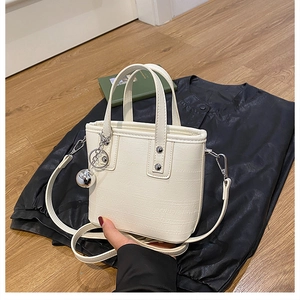 Détail du sac seau blanc crème avec cuir à motif croco et breloque boule argentée