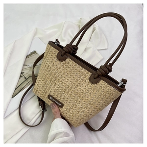 Detail of a trapezoidal straw bag with leather trim and unique knotted handle design