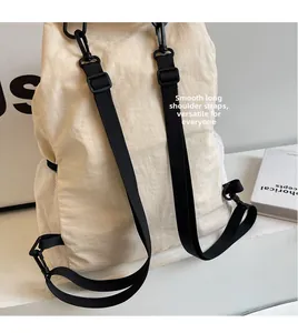 Detail of adjustable black shoulder straps and side mesh pocket on beige nylon backpack
