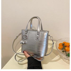 Détail du sac seau en cuir argenté texturé orné d'un pendentif boule métallique