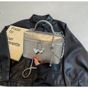 Détail du sac seau argenté métallisé avec pendentif cœur et bandoulière chaîne