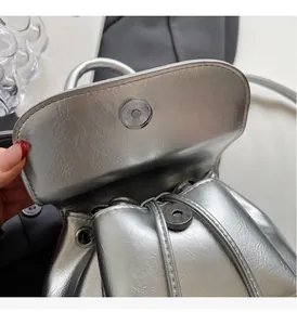 Dettaglio del mini zaino argento metallizzato con coulisse e chiusura magnetica in metallo