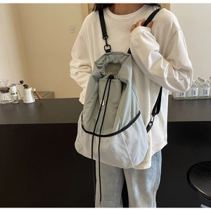 Detail of light blue nylon drawstring backpack with breathable white mesh paneling