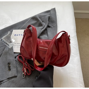 Détail du sac croissant en cuir verni plissé bordeaux avec bandoulière