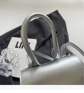 Dettaglio della borsa argento metallizzato con manico rotondo e cuciture curate