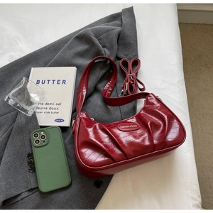 Gros plan du sac en croissant rouge foncé avec texture plissée et bandoulière