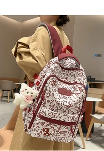 Nahaufnahme des Graffiti-Rucksacks mit roten Riemen und Plüschbär-Schlüsselanhänger