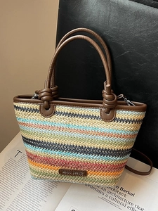 Colorful striped straw tote bag with brown leather knot handles for summer beach vacations