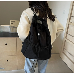 Detail of black nylon drawstring backpack with large mesh pocket and metal hook