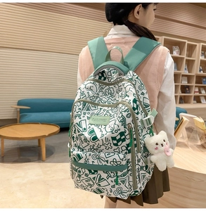 Seitenansicht eines weißen Graffiti-Rucksacks mit Plüschbären im Bibliotheks-Ambiente