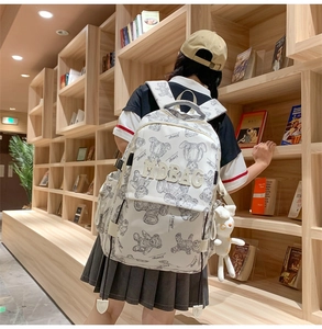Weißer Schulrucksack mit Bärenmuster, 3D-Stickerei und Plüschanhänger im Detail