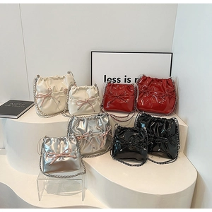 Chic bucket bags in multiple colors featuring ribbon bows and elegant chain straps