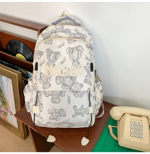 Detail eines weißen Studentenrucksacks mit Bärenprint und großem MDBAG-Logo