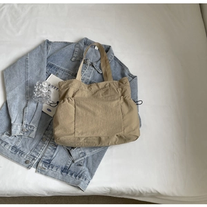 Detail van kaki geplooide shopper met zijzakken met trekkoord en brede schouderband