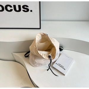 Detail view of the drawstring closure and inner pocket of this cream nylon backpack