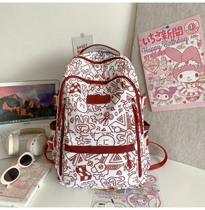 Detailansicht eines roten Graffiti-Rucksacks auf Schreibtisch mit Laptop
