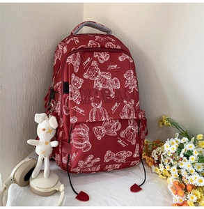 Detail eines burgunderroten Schulrucksacks mit Bärenmuster und MDBAG Stickerei