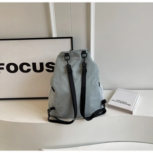 Detail view of sage green nylon backpack featuring breathable white mesh side pocket