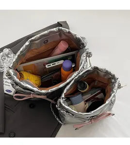 Silver metallic drawstring bag showing internal capacity for tablets and cosmetics