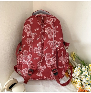 Detailansicht der Rückseite des roten Schulrucksacks mit Bärenmotiven und breiten Gurten