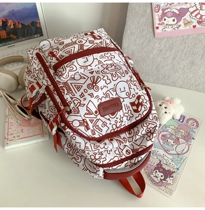 Detailansicht des rot-weißen Graffiti-Rucksacks mit Reißverschlüssen auf dem Schreibtisch