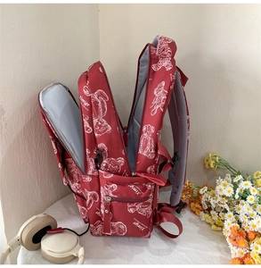 Detail eines roten Rucksacks mit mehreren Innenfächern und Bärenmuster-Aufdruck