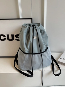 Light blue nylon drawstring backpack with white mesh inserts and adjustable black straps