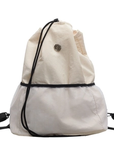 Minimalist cream nylon drawstring backpack with mesh pocket and round metal logo