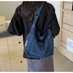 Detail of vintage denim crossbody bag showing thick fabric and white contrast stitching