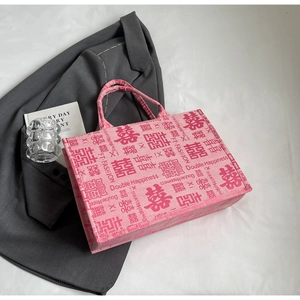 Detail van roze canvas bruidstas met rode Double Happiness-prints en stevige hengsels