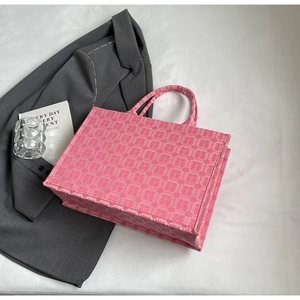 Detailweergave van de roze canvas shopper met geweven Xi-patroon op grijze basis