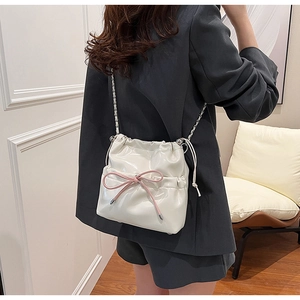 White PU leather drawstring bucket bag with pink bow and silver chain strap